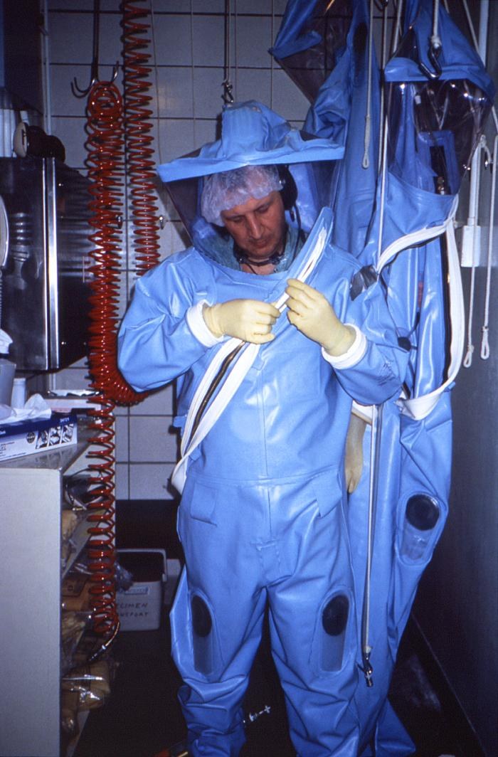 CDC laboratorian wearing a positive‑pressure biosafety suit before entering a maximum‑containment (BSL) laboratory.
