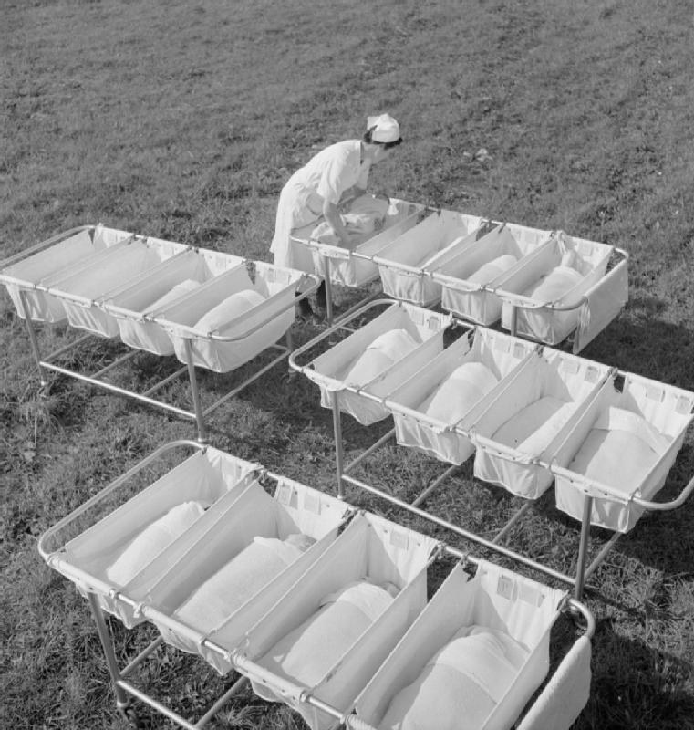 Historical photograph showing multiple newborn babies sleeping in cots at a hospital nursery (illustrative)