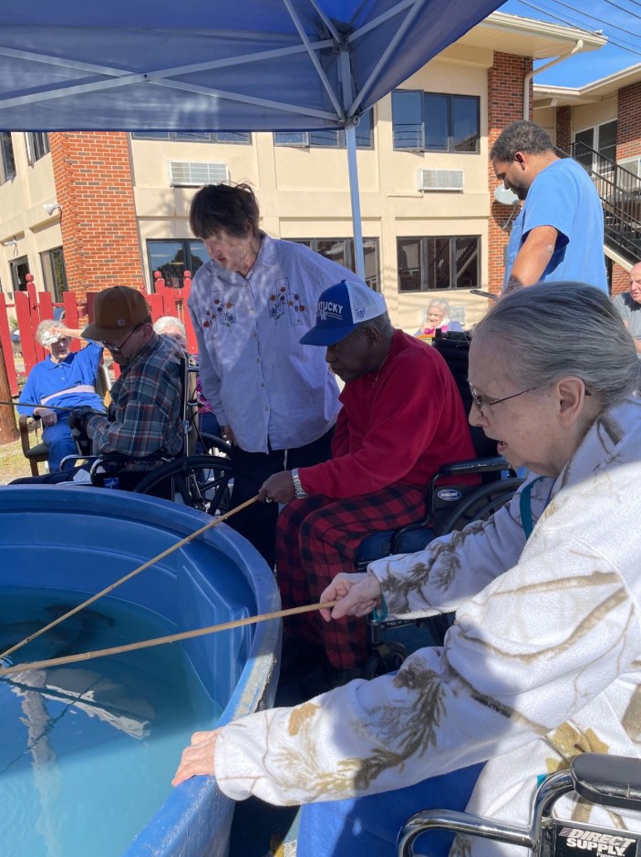 Nursing home residents participating in an outdoor fishing event at a rehabilitation and wellness centre — illustrative of community activities for older adults.